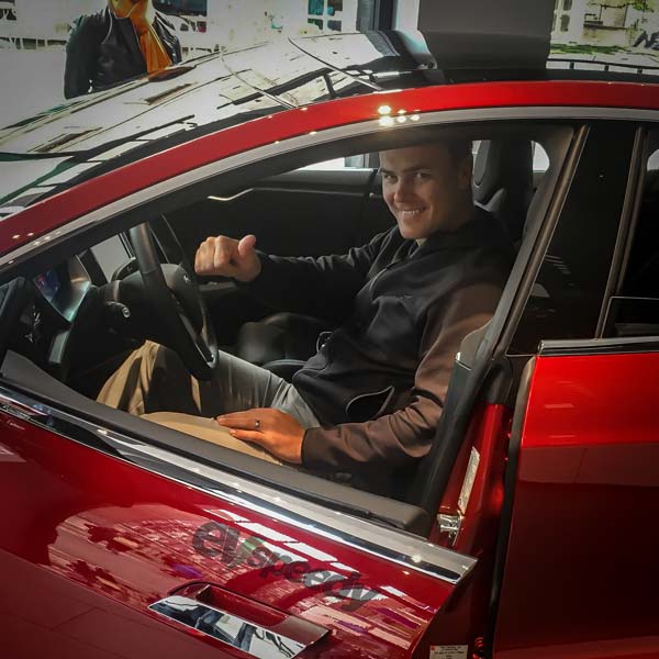 Erwin-Meyer-Sitting In A Red Tesla Model S