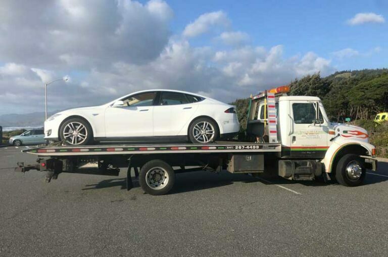 tesla towing on a flat bed truck
