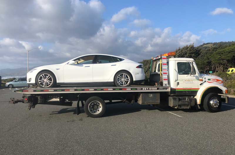tesla towing on a flat bed truck