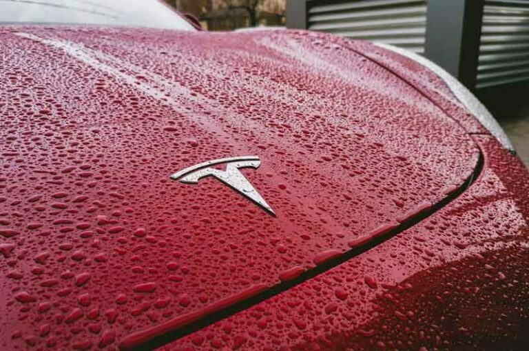 the-hood-of-a-red-tesla-covered-in-water-droplets-photo-taken-in-bucharest-after-a-heavy-rain